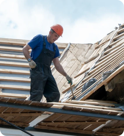 Construcción de Tejados 3 Trabajador con casco y martillo renovando un techo de madera en construcción, mostrando el proceso de reparación bajo un cielo nublado