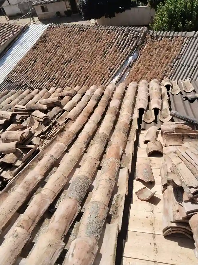 Reconstrucción de tejado en Humanes 1 Tejado en reparación con tejas antiguas removidas y tejas nuevas listas para instalar.