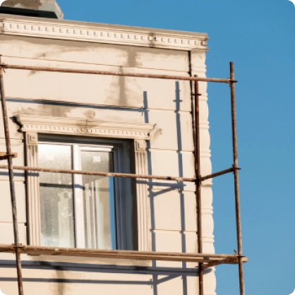 Fachada de edificio en construcción con andamios.