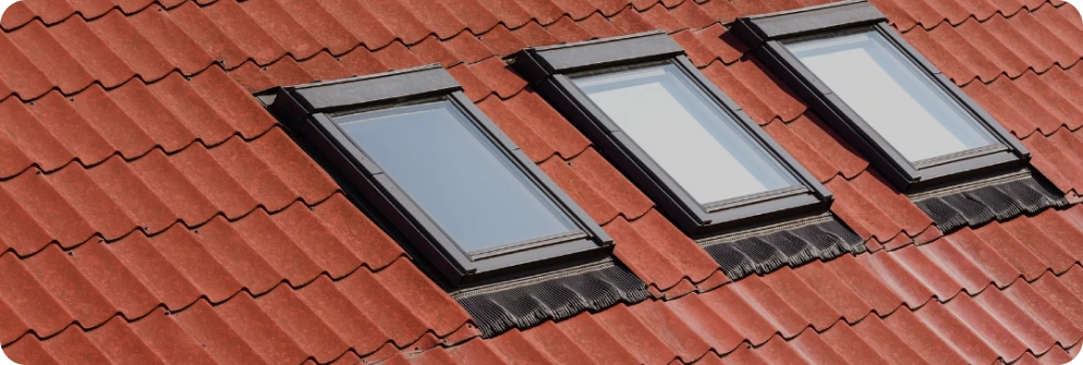Instalación de Claraboyas en Guadalajara 1 Serie de tres ventanas de techo VELUX en un tejado de tejas rojas en Guadalajara