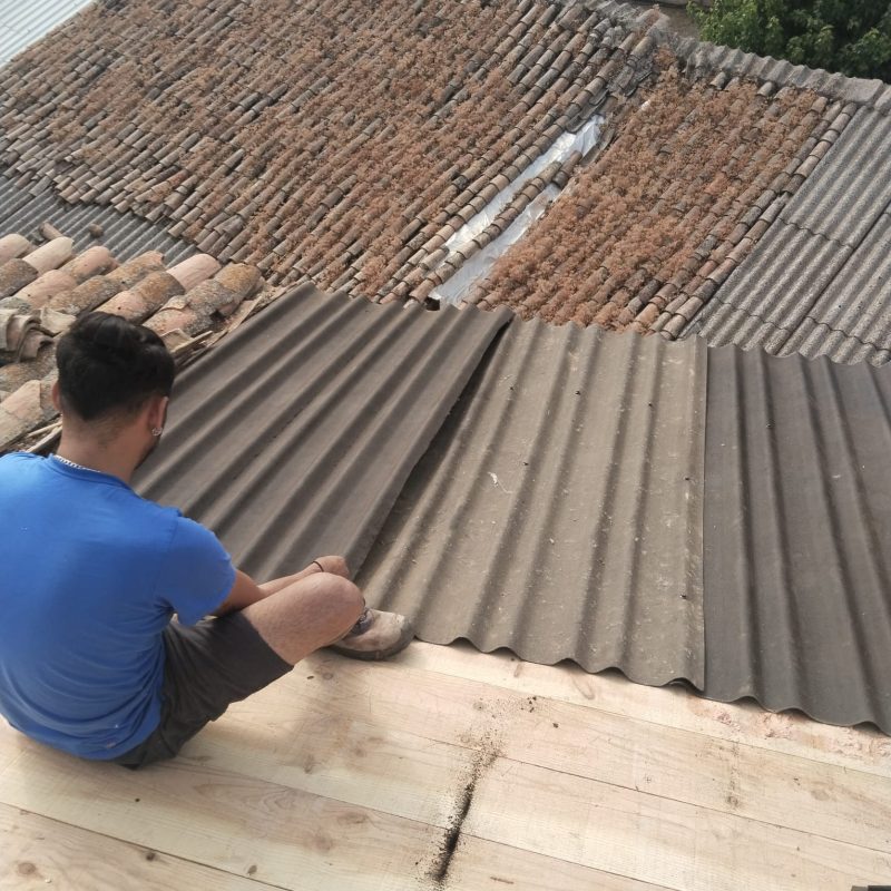 Trabajador instalando planchas en la reconstrucción de un tejado en Humanes